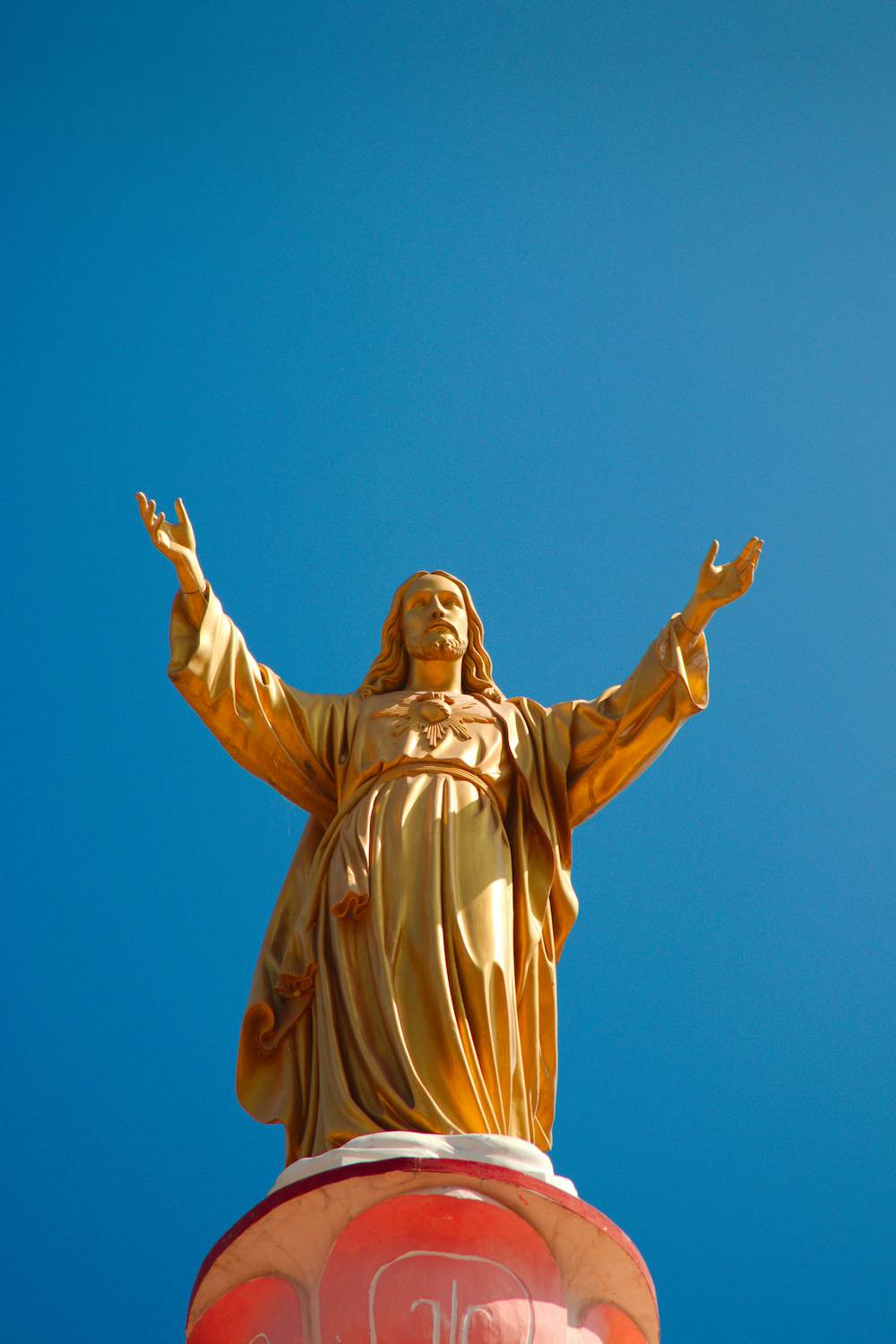 A statue of Jesus with his hands outstretched.